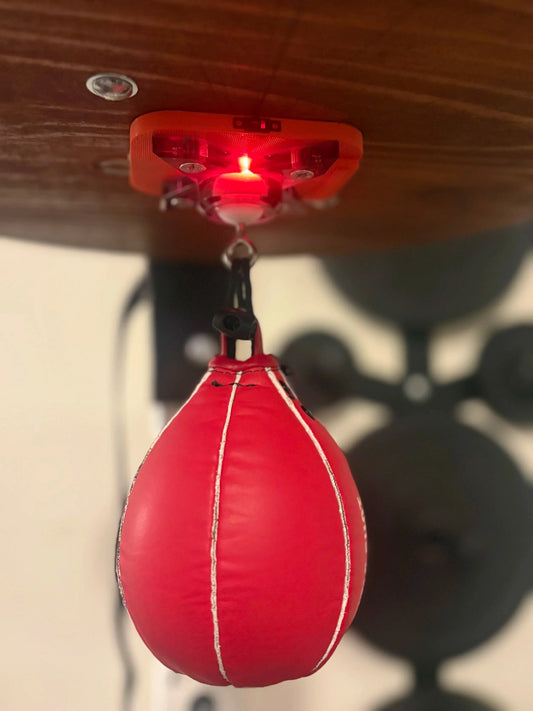 The Speedbag Champ counter under a platform, glowing red as it counts a red speed bag