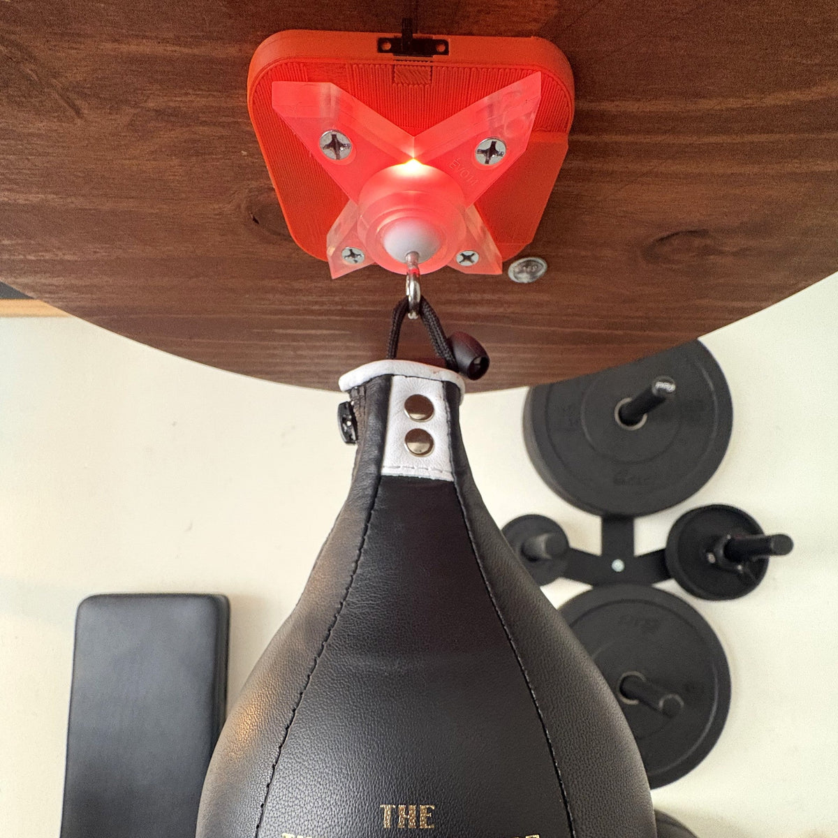 Counter + swivel, Standard: the Speedbag Champ counter and EVO14 swivel under a platform, glowing red above a black speed bag